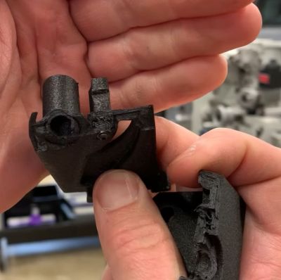PAHT-CF part printed at 45 degrees, with reinforcing bolt, post-failure. (Credit: Functional Print Friday, YouTube)